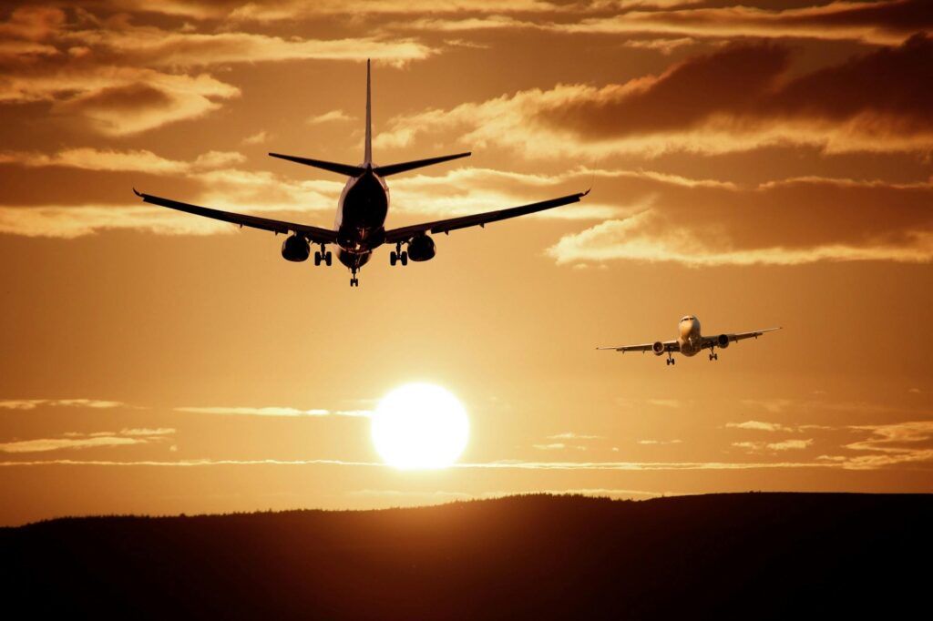 Silhouetted airplanes landing against a dramatic sunset sky, capturing the essence of flight.